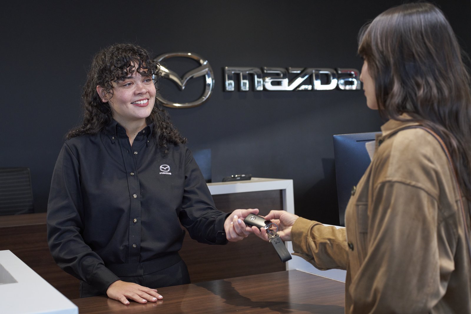 A Mazda of Gladstone team member handing car keys to a customer